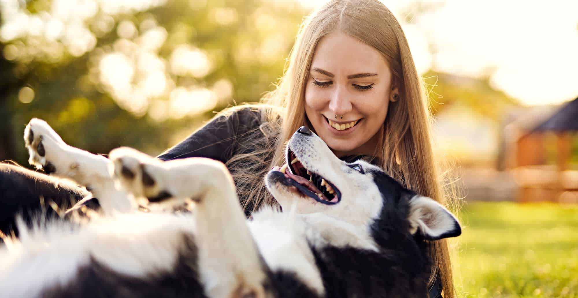 A woman playing with her husky
